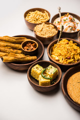 Group of Gujarati snacks like jalebi-fafda, thepla, khaman dhokla, aloo bhujiya, khandvi,khakra, dahi vada, gathiya with hot tea