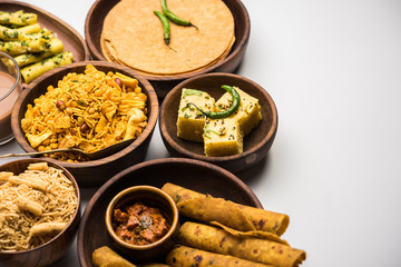 Group of Gujarati snacks like jalebi-fafda, thepla, khaman dhokla, aloo bhujiya, khandvi,khakra, dahi vada, gathiya with hot tea