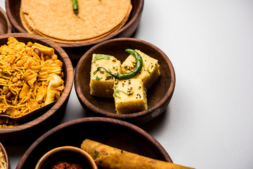 Group of Gujarati snacks like jalebi-fafda, thepla, khaman dhokla, aloo bhujiya, khandvi,khakra, dahi vada, gathiya with hot tea