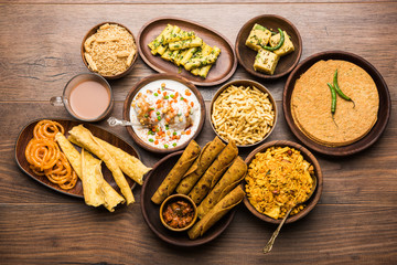 Group of Gujarati snacks like jalebi-fafda, thepla, khaman dhokla, aloo bhujiya, khandvi,khakra, dahi vada, gathiya with hot tea