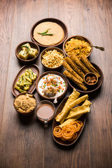 Group of Gujarati snacks like jalebi-fafda, thepla, khaman dhokla, aloo bhujiya, khandvi,khakra, dahi vada, gathiya with hot tea