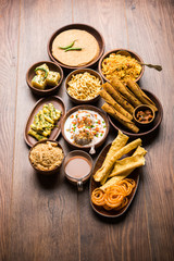 Group of Gujarati snacks like jalebi-fafda, thepla, khaman dhokla, aloo bhujiya, khandvi,khakra, dahi vada, gathiya with hot tea