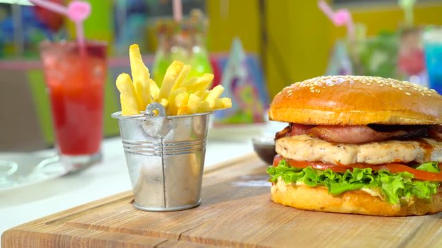 Festive lunch with burger, french fries and some colored cocktails.