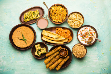 Group of Gujarati snacks like jalebi-fafda, thepla, khaman dhokla, aloo bhujiya, khandvi,khakra, dahi vada, gathiya with hot tea