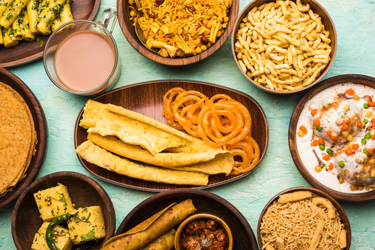 Group of Gujarati snacks like jalebi-fafda, thepla, khaman dhokla, aloo bhujiya, khandvi,khakra, dahi vada, gathiya with hot tea
