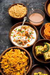 Group of Gujarati snacks like jalebi-fafda, thepla, khaman dhokla, aloo bhujiya, khandvi,khakra, dahi vada, gathiya with hot tea