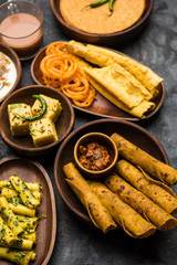 Group of Gujarati snacks like jalebi-fafda, thepla, khaman dhokla, aloo bhujiya, khandvi,khakra, dahi vada, gathiya with hot tea