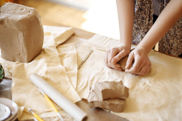 female hands cutting clay