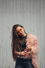 Portrait of One Stylish Girl in Pink Coat and Modern Yellow Sunglasses Posing on Street