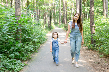 Obraz premium Nature, motherhood and child concept - Happy mother and little daughter have fun in green park