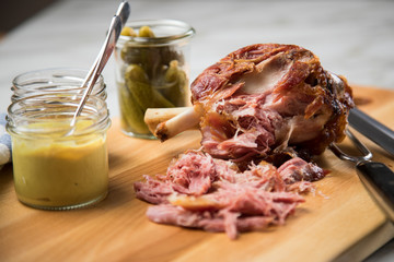 Gegrilltes Schweinefleisch Haxen Fleisch auf Holzbrett mit Cornichons, süßen und mittelscharfen...