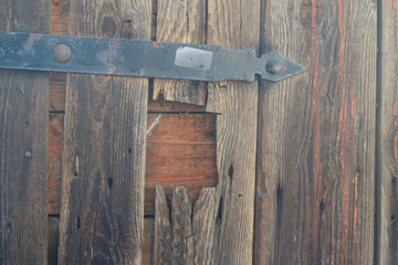 Wooden door with a hole and metal element, closeup