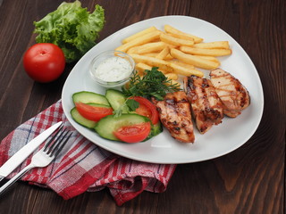 Grilled steaks, French fries and vegetable salad