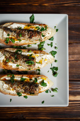 toast with sardines on a wood background closeup. top view