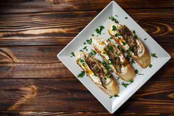 toast with sardines on a wood background closeup. top view