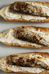 toast with sardines on a wood background closeup. top view