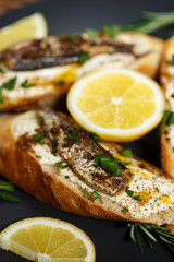 toast with sardines on a wood background closeup. top view