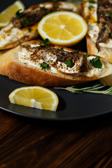 toast with sardines on a wood background closeup. top view