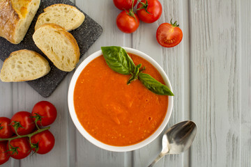 Tomato soup in the white bowl on the grey wooden background.Top view.Copy space.