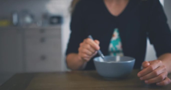 Young mother and toddler eating breakfast together in kitchen