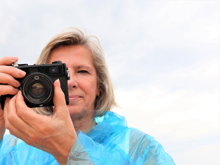 middle aged female photographer taking photos outdoors.