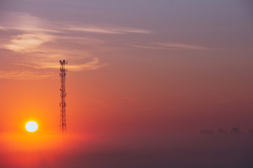 Cell tower in the fog during sunrise