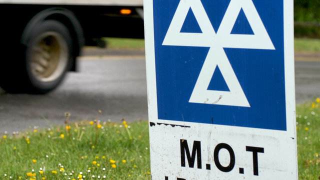 Blue MOT Service Sign On British Road On Cloudy Rainy Day