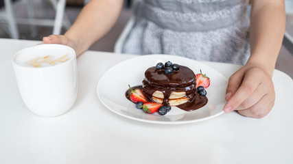 Healthy summer breakfast, homemade classic american pancakes with fresh berrys and chocolate, morning lightwhite background copy space top view