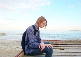 Teen schoolboy sitting on the beach