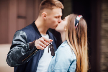 Fototapeta premium Happy couple kissing and showing keys of new home .
