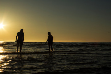 silhouette of a girl and a guy in the sea
