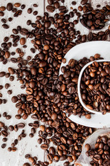 Black coffee in white cup and coffee beans on light wooden background. Top view, space for text