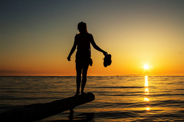 silhouette of a girl at sunset on the background of the sea