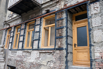 The building is in the process of reconstruction of the view from the street. Wooden door and windows, brick walls and metal supports