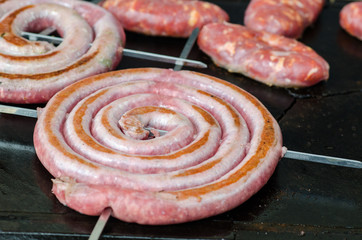 the sausage browned on the barbecue plate is a dish that cannot be missed in outdoor parties.