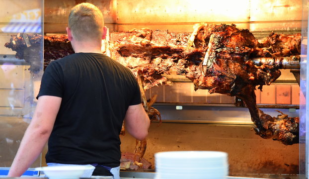 Grillmeister an einem riesigen Ochsen am Spie&szlig;