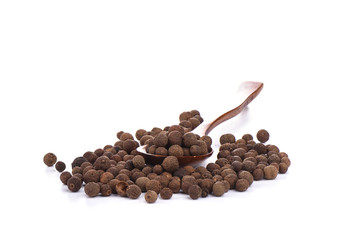 Pepper allspice on wooden spoon isolated on white background. Jamaican bell pepper.