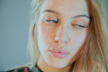 beautiful blonde with blue eyes in plaid dress touches her hair. Young actress shows acting exercises. woman actively expresses her emotions and poses for camera