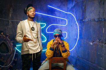 Fototapeta na wymiar Two black rappers, neon lights on background