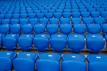 Rows of blue seats in the stand in the sports arena