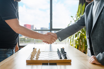Male chess players shake hands before the game