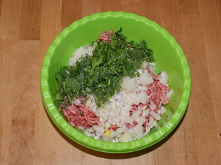 Мясной фарш с приправами и зеленью в зелёной миске