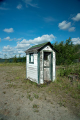 Small wooden shed in white and green faded paint