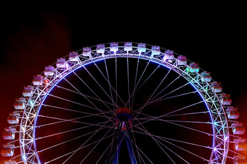 Ferris wheel at amusement park by night