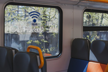 empty train carriage with multicolored seats and a sticker on the window WI-FI