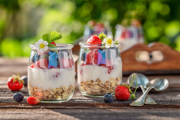 Closeup of granola in jar with yoghurt and berries