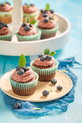 Brown muffin with blueberries and chocolate cream