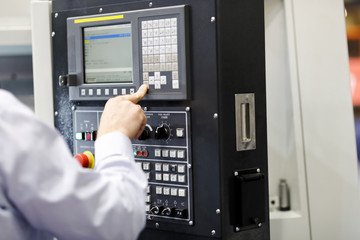 CNC machine operator working with a control panel