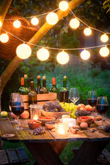 Table with wine and fruits in the summer evening