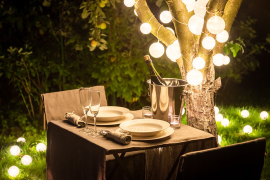 Illuminated Table For Two In Evening Garden